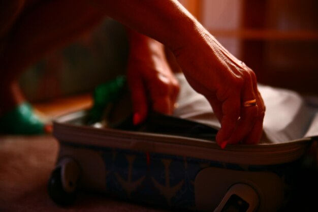 Photo close-up of woman packing suitcase