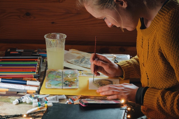 Клоуз-ап женщины, рисующей акварель