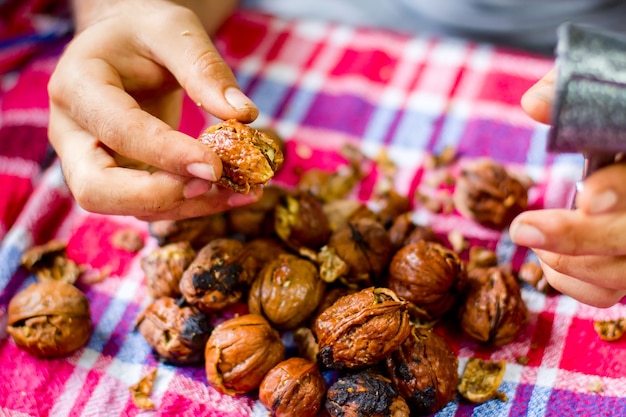 Close up of a woman peeling walnuts close up