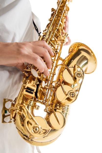 Close up woman playing saxophone isolated on white studio background. Inspired musician, details of art occupation, world classic instrument for jazz and blues. Concept of hobby, creativity.