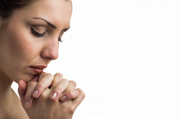 Close-up of woman praying with eyes closed