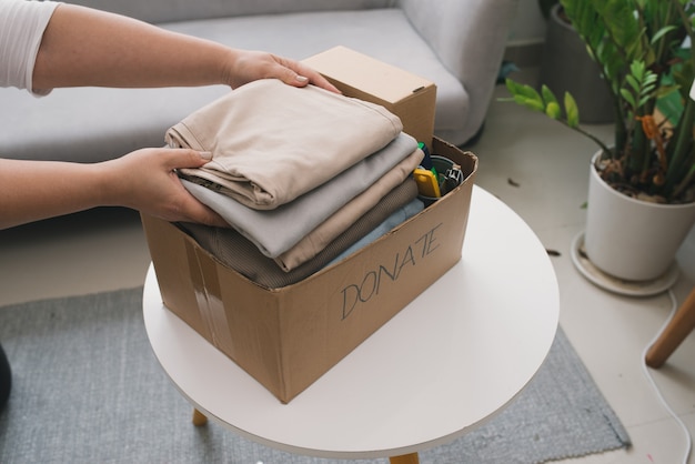 Close-up Of A Woman Putting Clothes Inside Donation Box