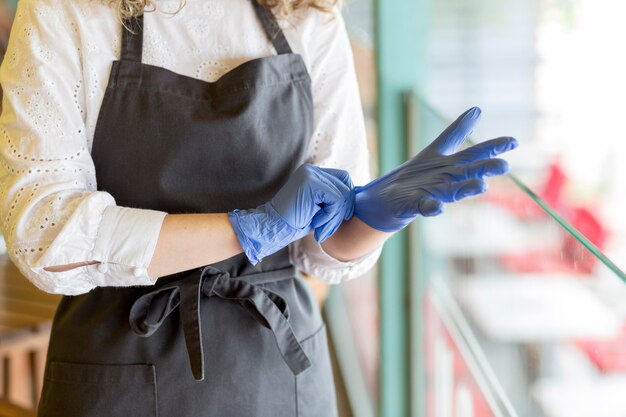 Close-up woman putting on gloves