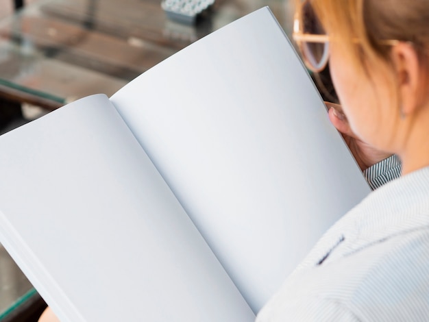 Close-up woman reading a mock-up magazine