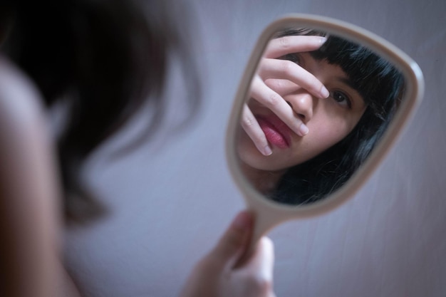 손 거울 에 반사 되는 여자 의 클로즈업