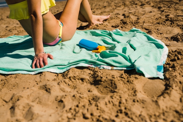 Foto primo piano della donna che si distende sulla spiaggia sabbiosa