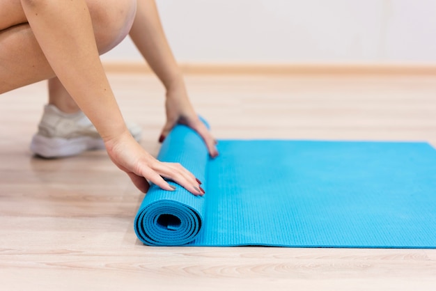 Photo close-up woman rolling fitness mat