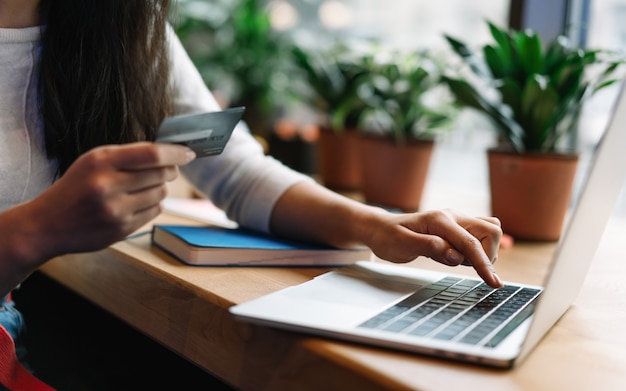 Close up woman's hand holding credit card, shopping online