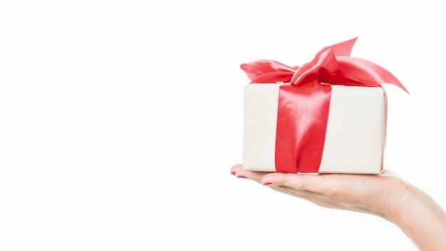 Photo close-up of a woman's hand holding gift on white background