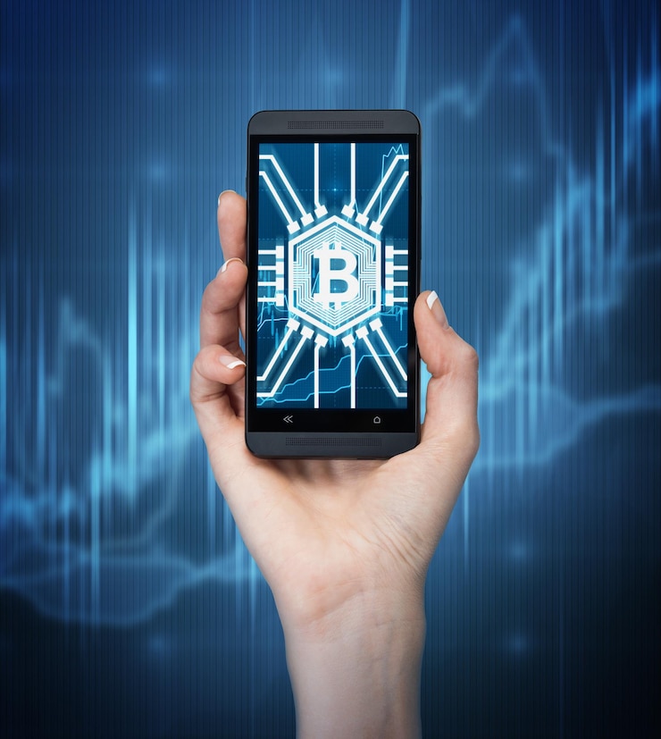 Photo close up of a woman s hand holding a smartphone with a bitcoin symbol on its screen. dark blue background with graphs.