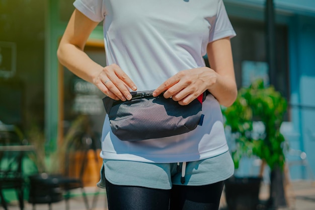 Photo close up woman's hand is taking something from her waistbag