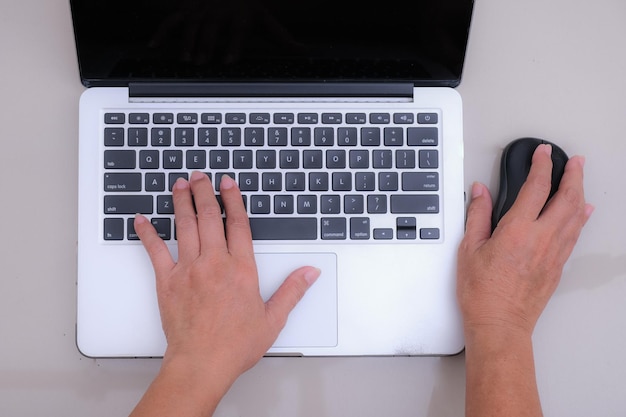 Photo close up a woman's hand on laptop keyboard other hand on mouse