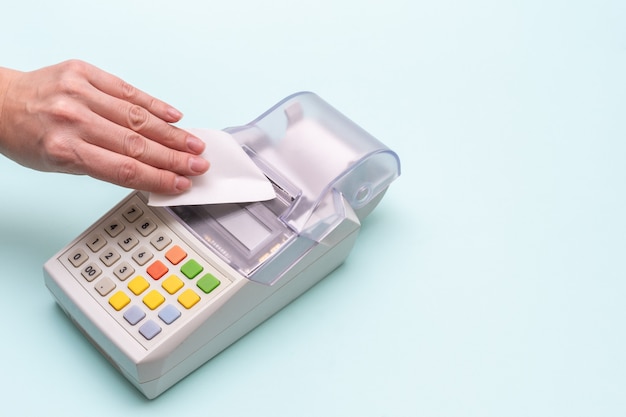 Close-up of a woman's hand tearing a check from an old cash register