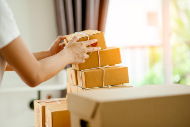 Close up of a woman's hands arranging a box of goods to be delivered to customers