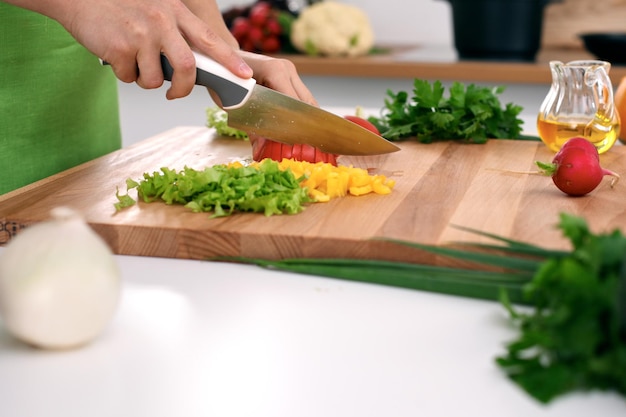 Close up of woman's hands cooking in the kitchen Housewife slicing fresh salad Vegetarian and healthily cooking concept