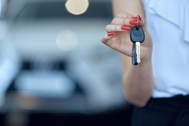 Close-up of a woman's hands holding the keys to a new car