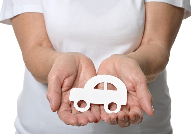 Close up of woman&amp;#39;s hands holding model car isolated on white background