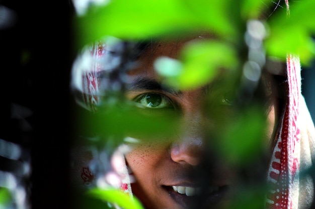 Photo close-up of woman seen through plant