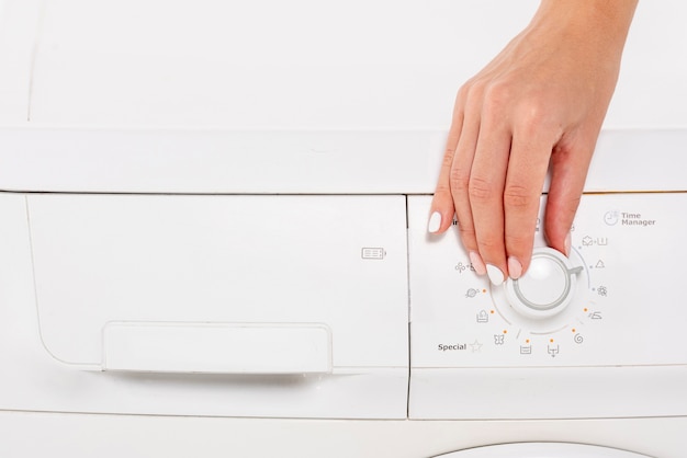 Close-up woman setting the washing machine