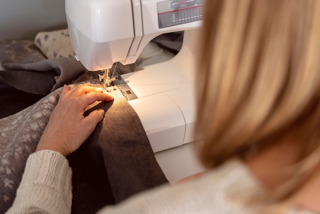Photo close-up woman sewing on white sewing machine