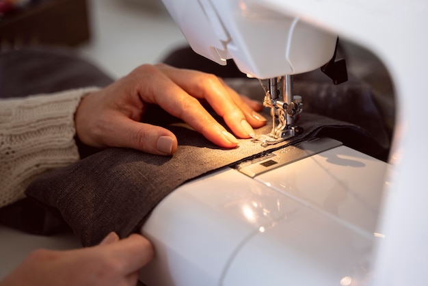 Photo close-up woman sewing on white sewing machine