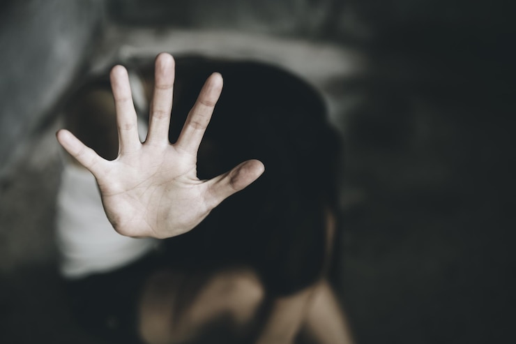 Photo close-up of woman showing stop sign while sitting indoors