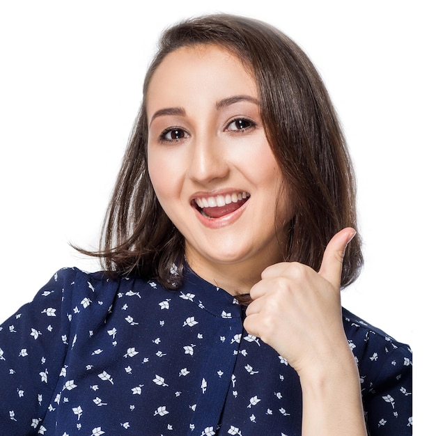 Close-up of woman showing thumb up with smile on white background