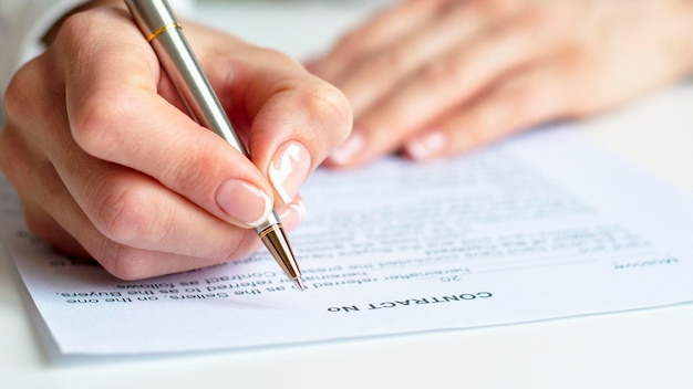 Foto primo piano di una donna che firma un contratto