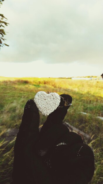 Photo close-up of woman sitting on field against sky