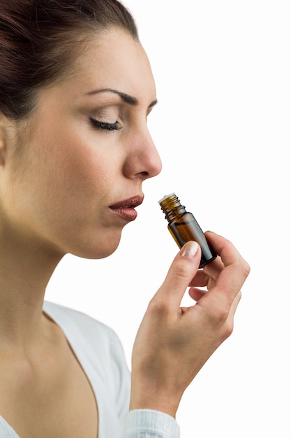 Крупный план женщина, пахнущая бутылку с лекарством