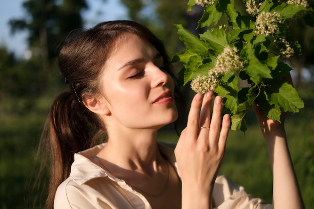 植物の匂いを嗅ぐ女性をクローズアップ