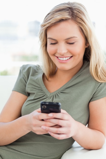 Close up, woman smiling and using her phone