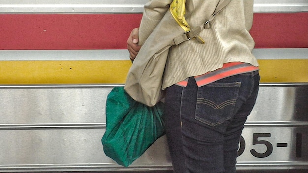 Foto close-up di una donna appoggiata al muro