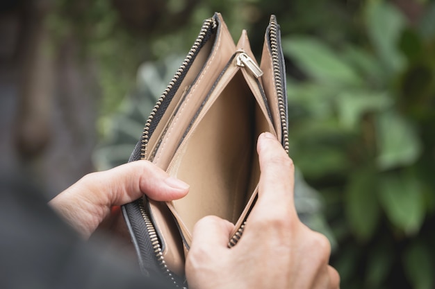 Close-up woman standing and holding the wallet empty of money