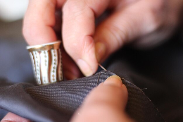 Photo close-up of woman stitching fabric