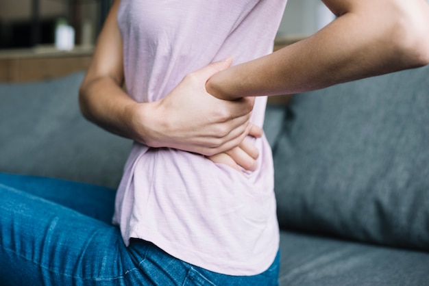 Foto primo piano di una donna che soffre di mal di schiena