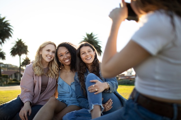 Chiuda sulla donna che cattura le foto degli amici