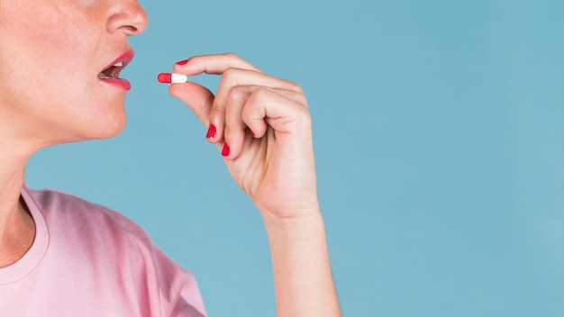 Foto primo piano di una donna che prende la capsula della vitamina per salute