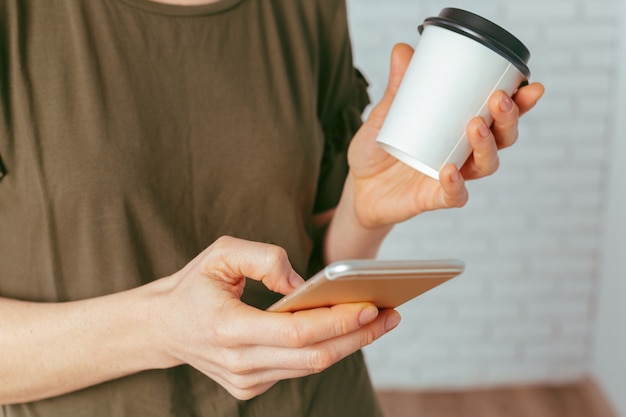 Chiuda in su della donna che manda un sms sullo smartphone