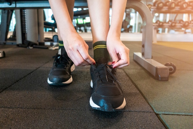 Photo close up woman tie up her shoe in gym