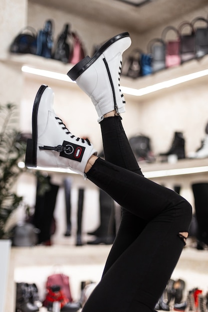 Photo close up of woman trying on white boots