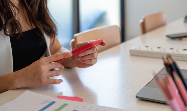 Close up woman use of smart phone with business on working space at home office