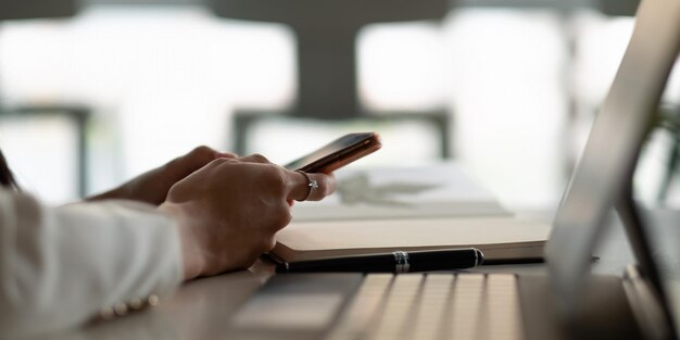 Photo close up woman use of smart phone on workplace at office