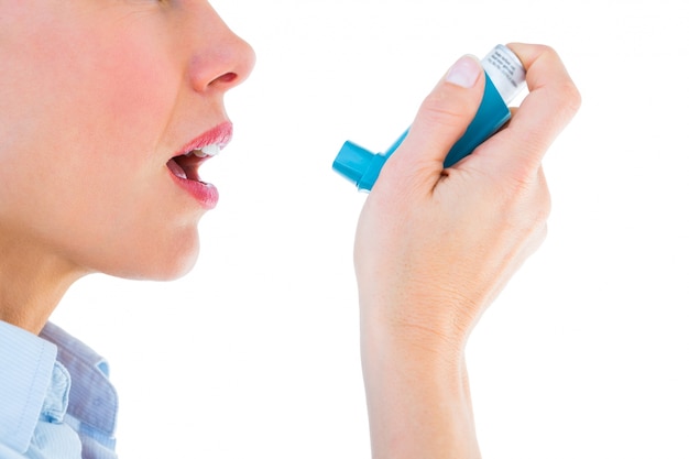 Закройте женщину, используя ингалятор для астмы