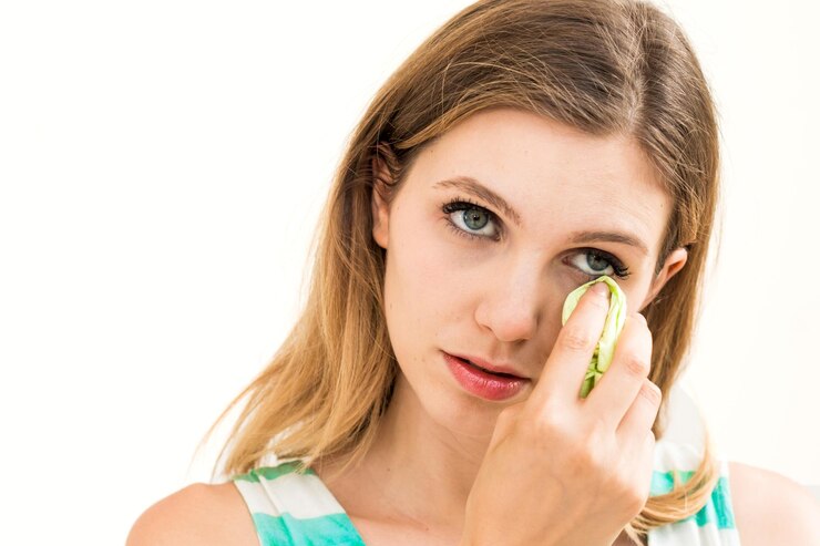 Close-up of woman using facial tissue against white background