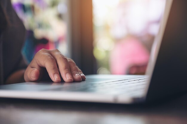 Photo close-up of woman using laptop in cafe