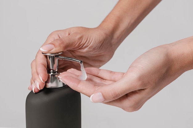 Close-up woman using liquid soap