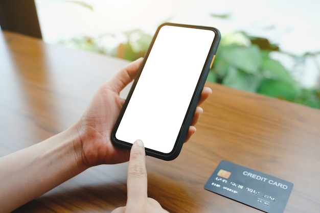 커피숍에서 모바일 빈 스마트폰과 신용카드로 마사지를 보내는 여성 클로즈업