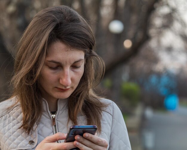 Photo close-up of woman using mobile phone in city