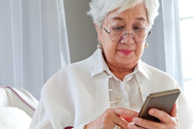 Photo close-up of woman using mobile phone indoors